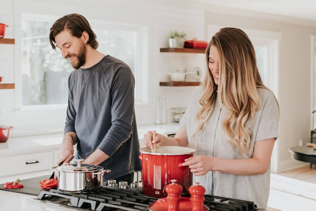 Frau und Mann kochen gemeinsam in der Kueche