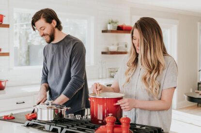 Frau und Mann kochen gemeinsam in der Kueche