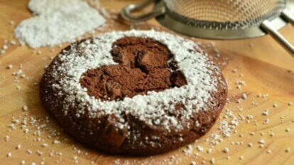 Ein Schokoladen-Cookie mit einem gepuderten Herz.