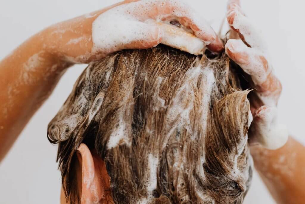 Person shampooniert sich die Haare