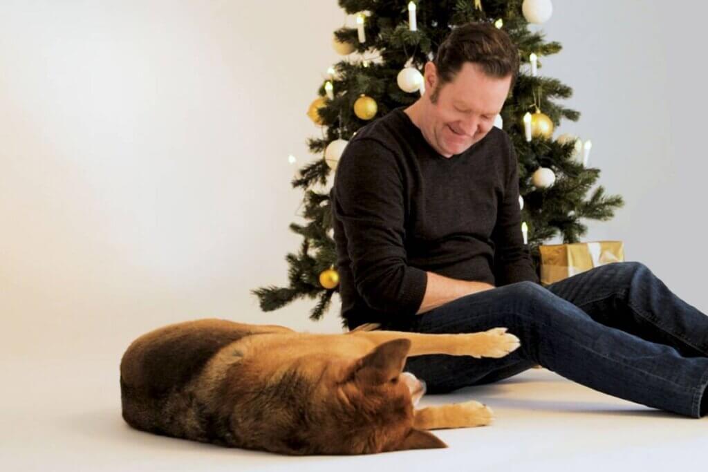 Juergen Tonkel mit Hund vorm Weihnachtsbaum