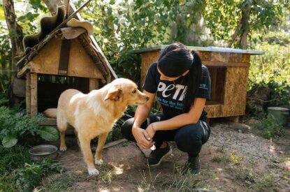 PETA Mitarbeiterin kniet neben Hund