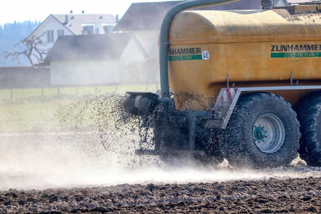 Feld wird mit Guelle geduengt