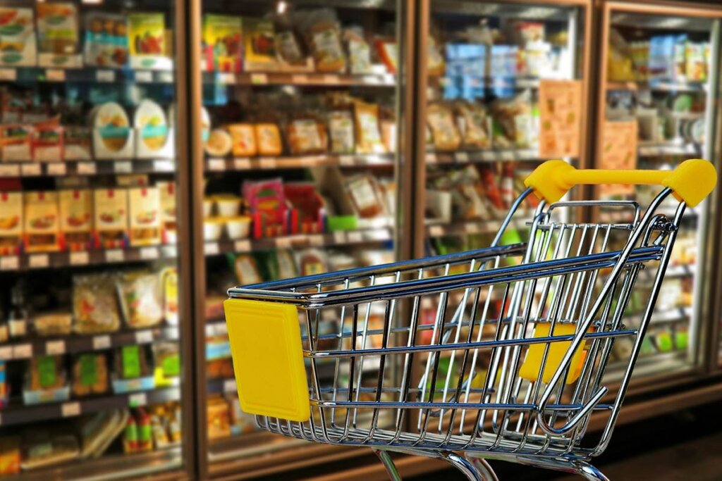 Einkaufswagen vor Supermarktregal