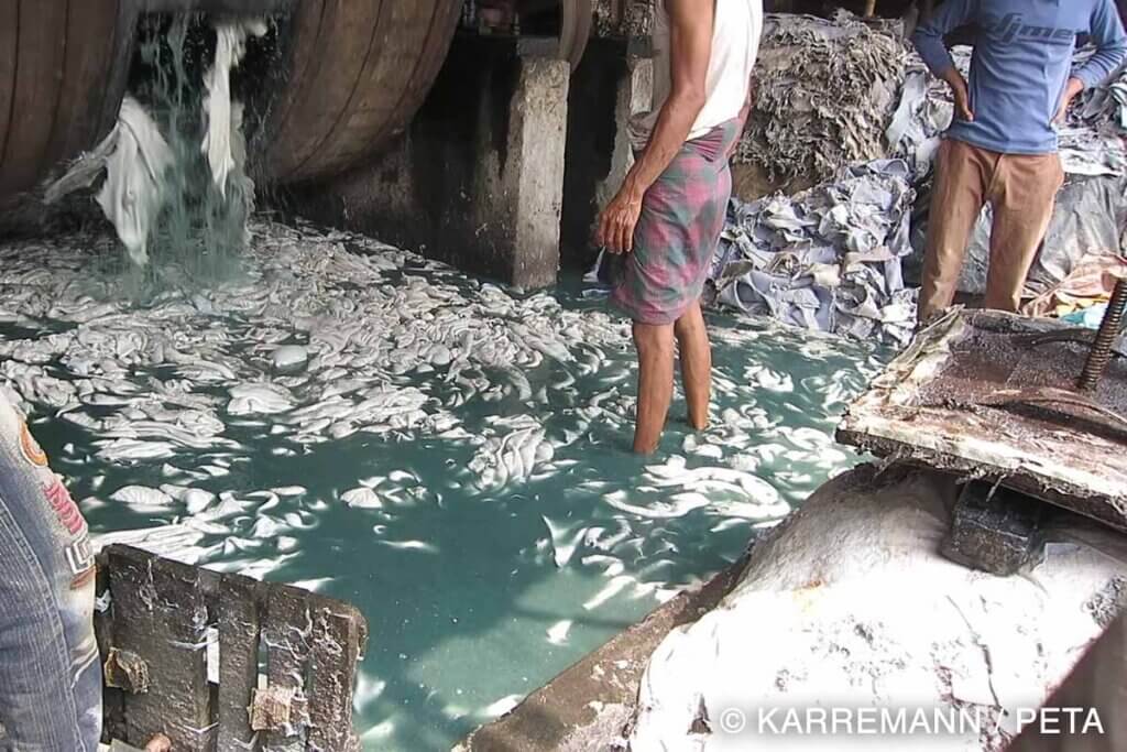 Menschen stehen im Abwasser bei der Lederproduktion