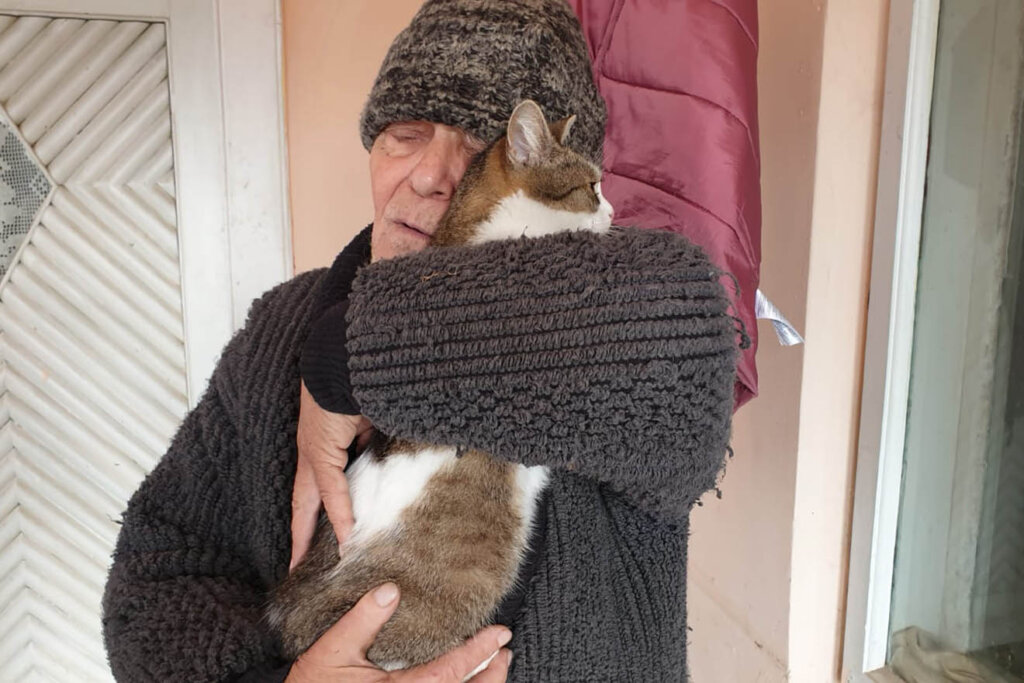 Mann haelt Katze im Arm