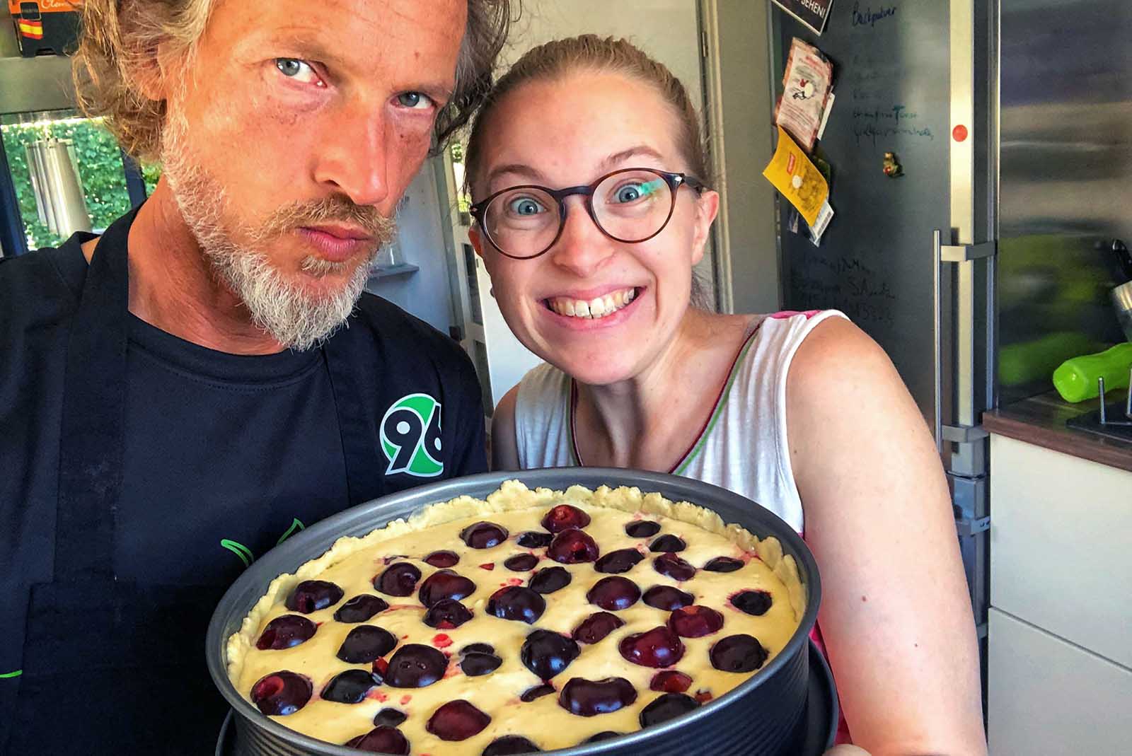 mann und frau halten einen kuchen in die kamera