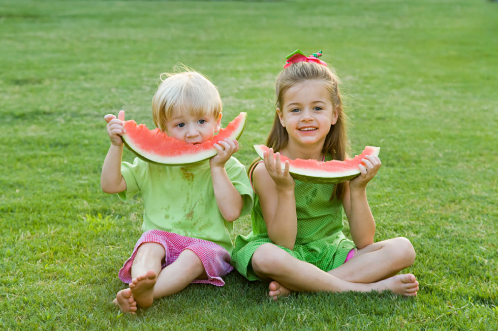 Kinder essen Melone