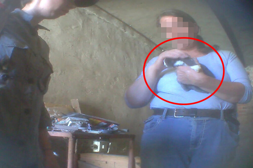 Frau haelt Hund auf dem Arm