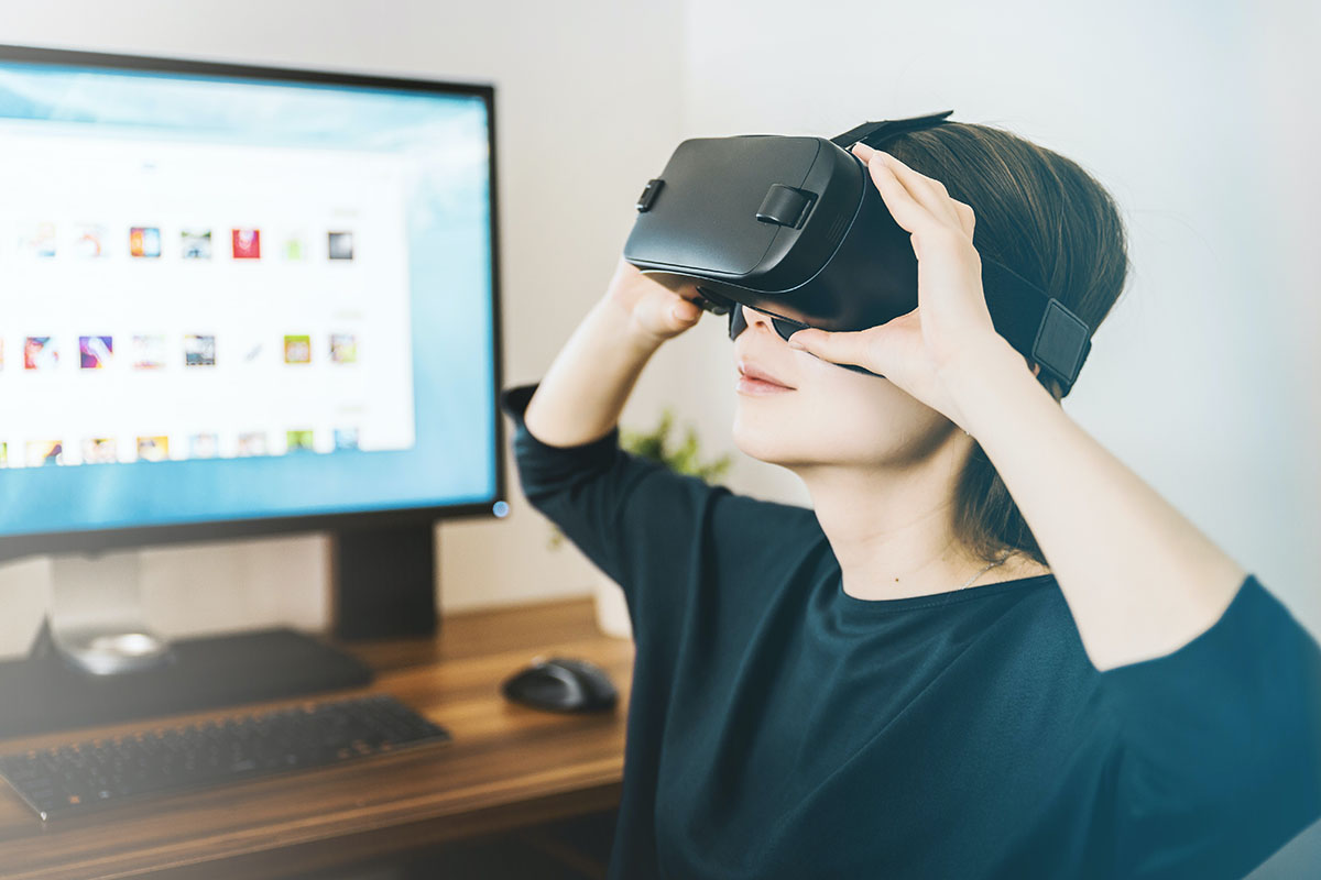 Frau mit VR Brille sitzt vor einem Computer