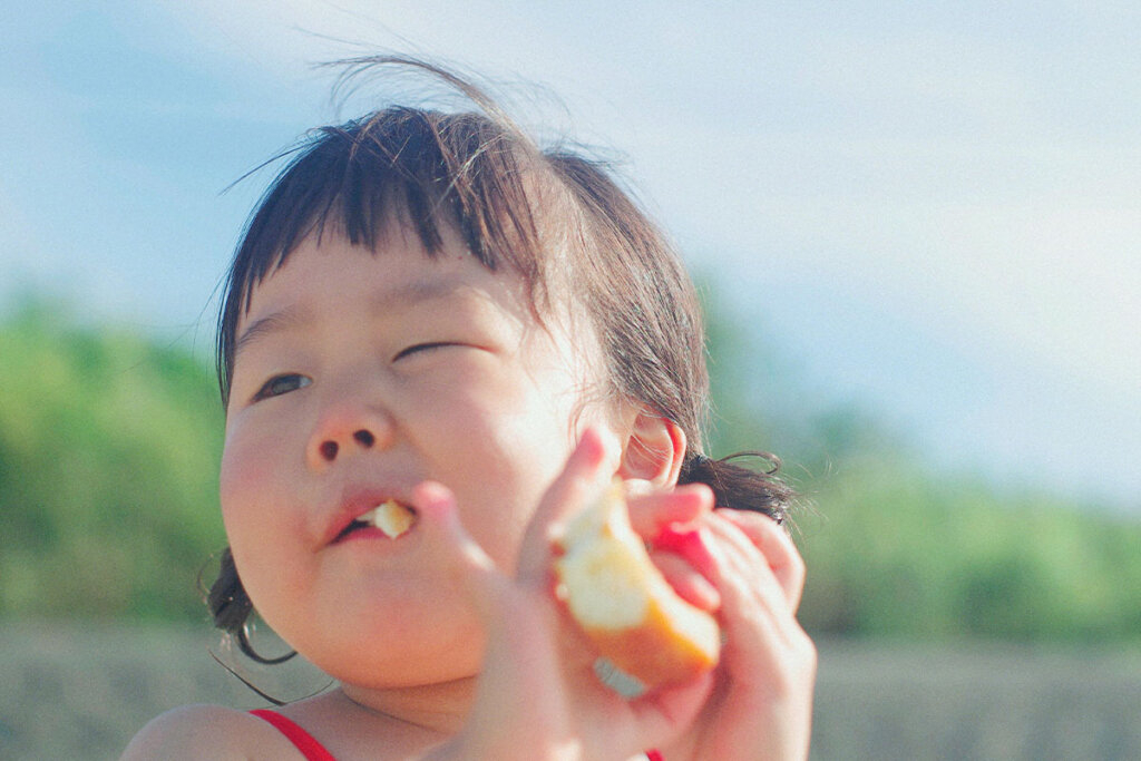 Kind isst einen Apfel.