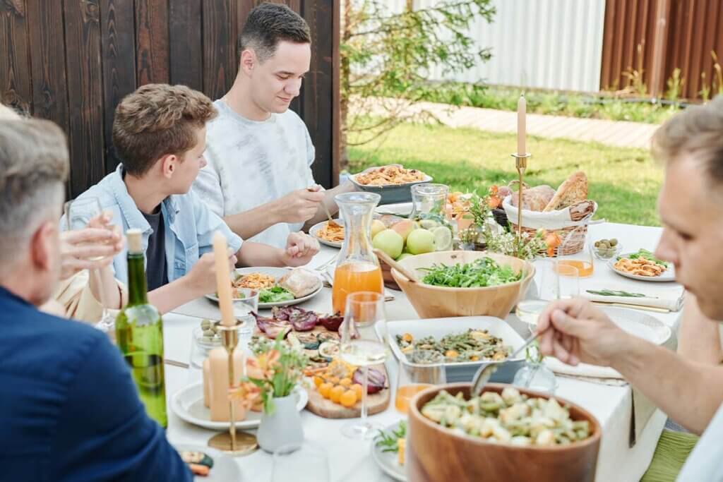 Eine Familie sitzt an einem bunt gedecktem Tisch und isst.
