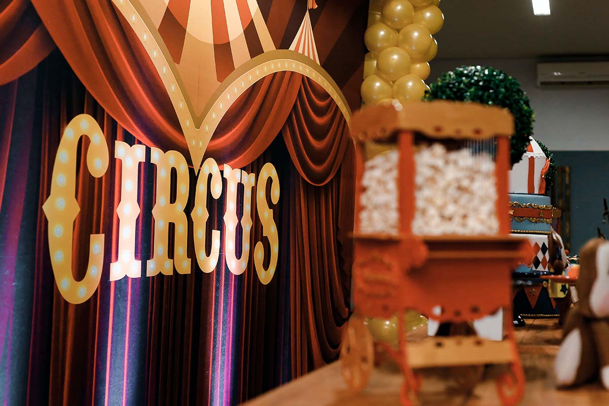 Eine kleine Popcornmaschine auf einem Tisch vor einem Vorhang mit der Aufschrift Circus.