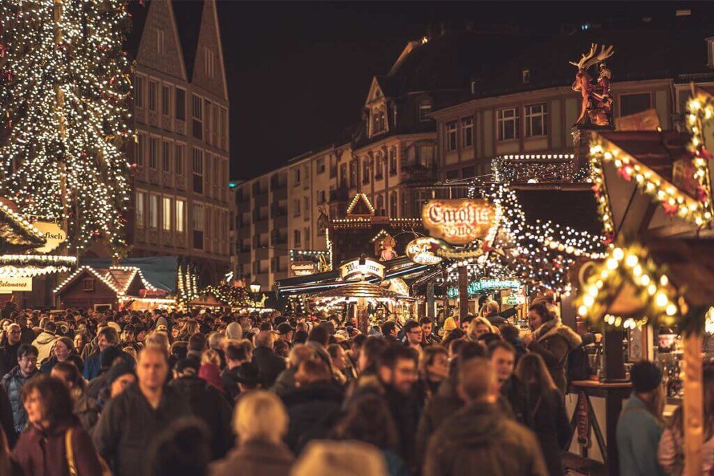 Menschen auf einem Weihnachtsmarkt am Abend