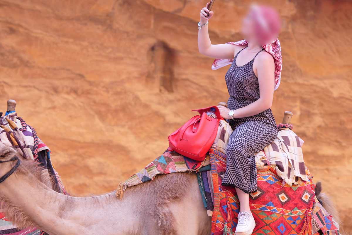Touristin reitet auf Kamel