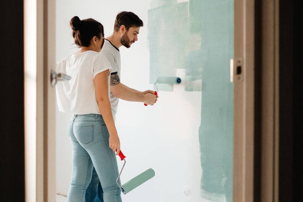 Mann und Frau streichen Wand