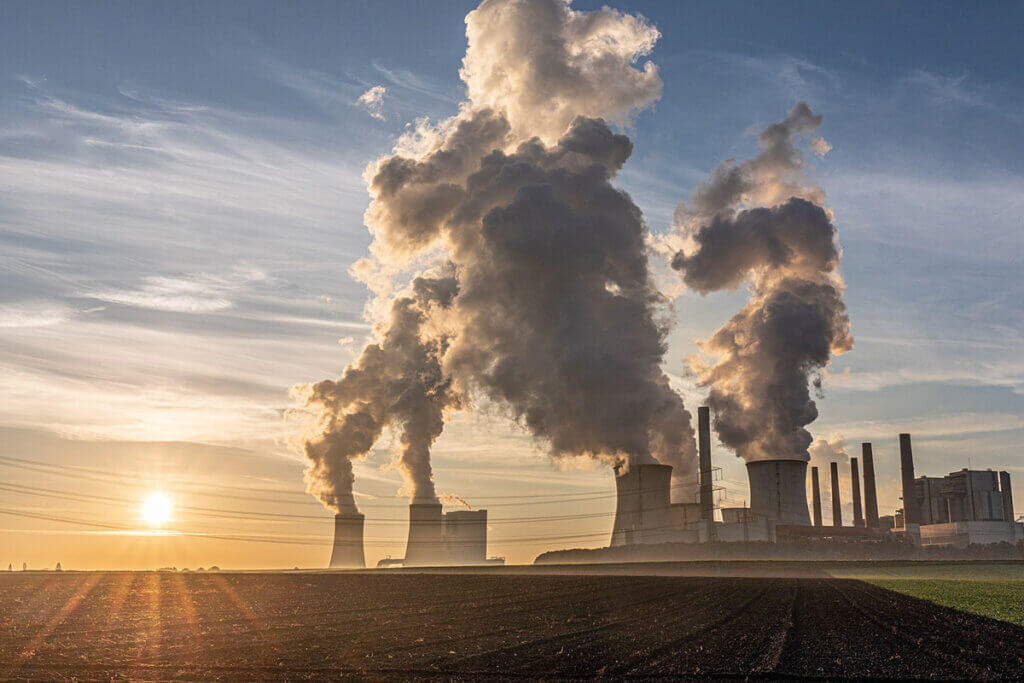 Ein Kraftwerk stoesst Treibhausgase in die Luft.