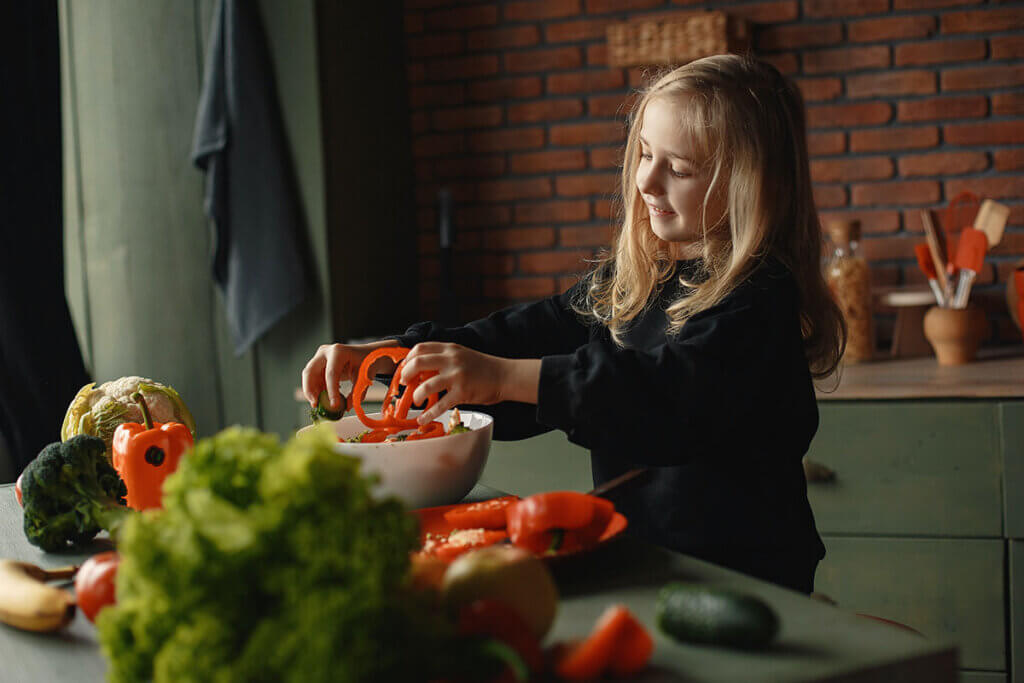Kind bereitet Gemuese zu