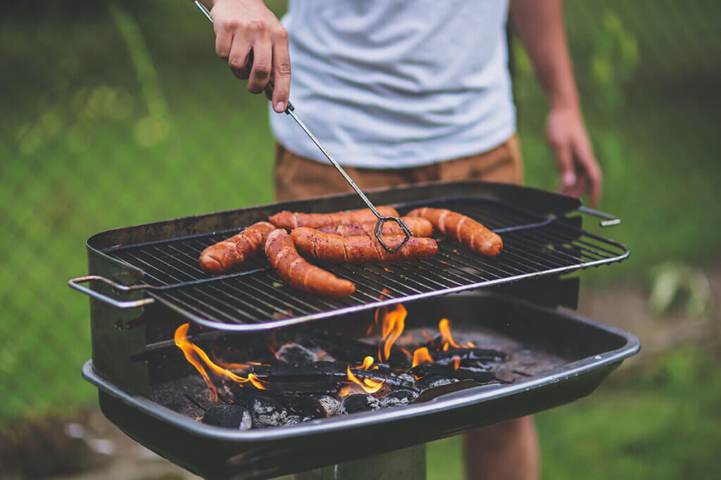 Mann braet Fleisch auf dem Grill