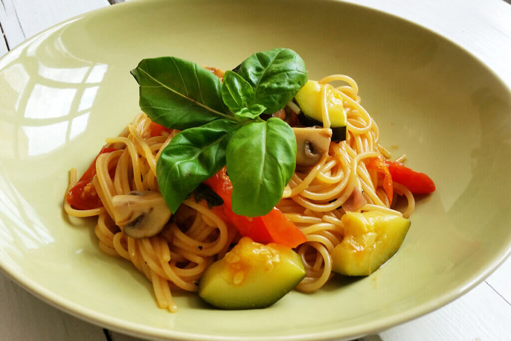 Teller mit Spaghetti und Gemüse.