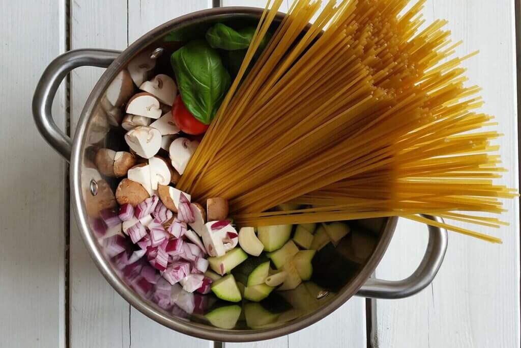 Geschnittene Champignons, Zucchini, Zwiebeln, Tomaten und Basilikum.