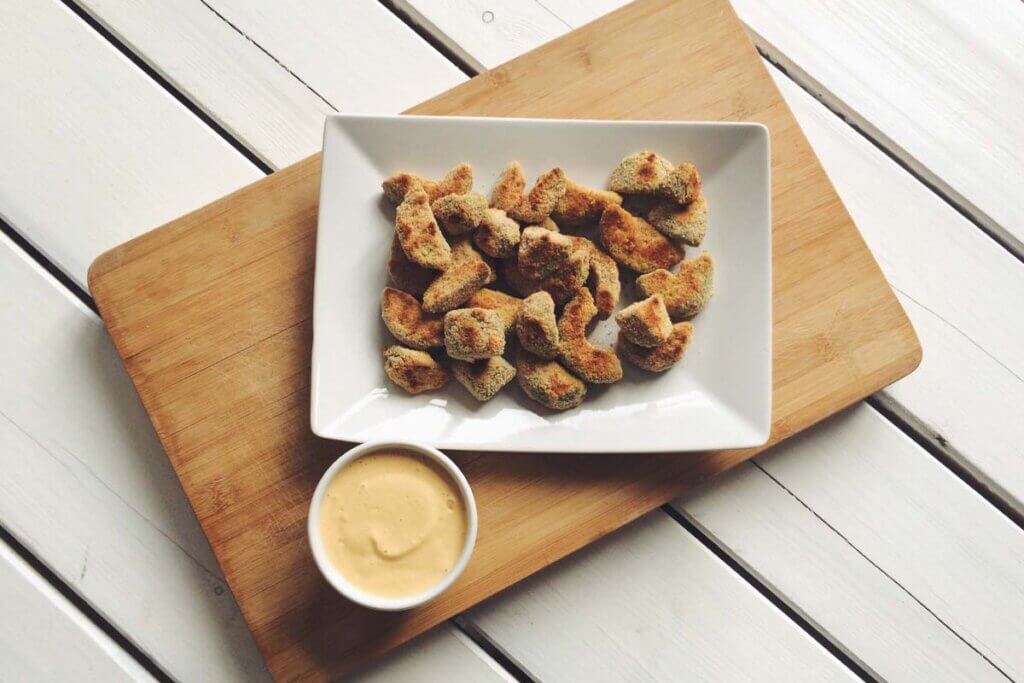 Gebackene Avocado Snacks in einer Schuessel mit Dip.