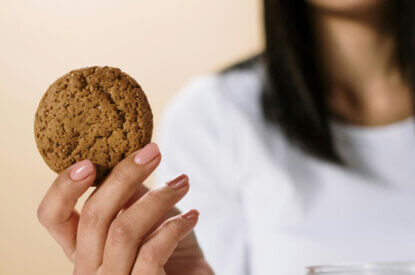 Eine Frau healt einen veganen Keks in der Hand.