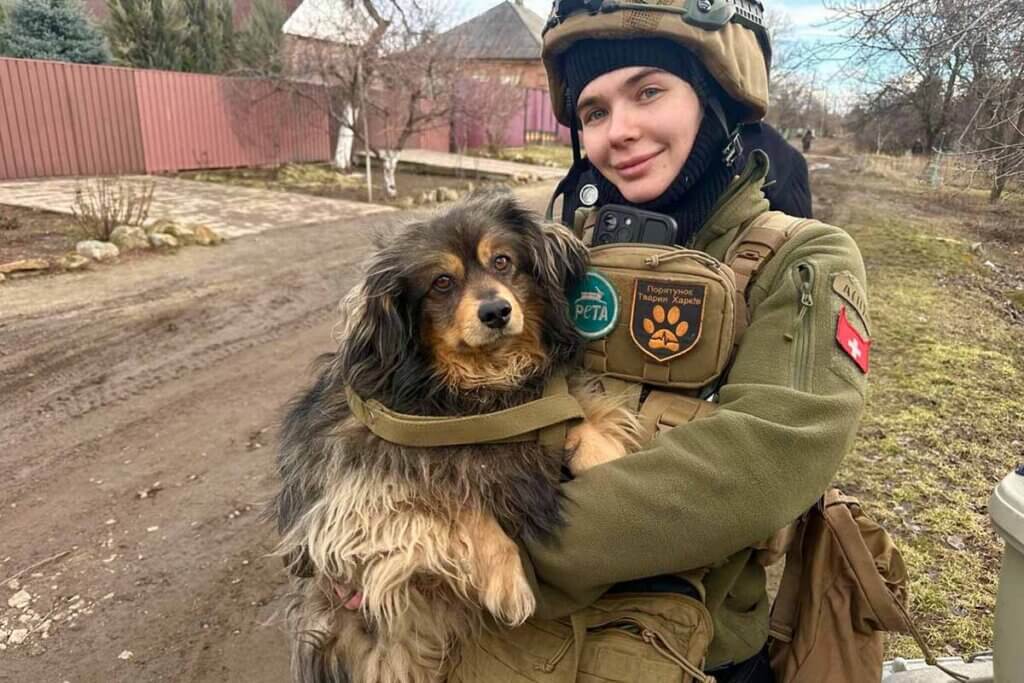 Sabrina hält einen geretteten Hund in den Armen und schaut freudenstrahlend in die Kamera.