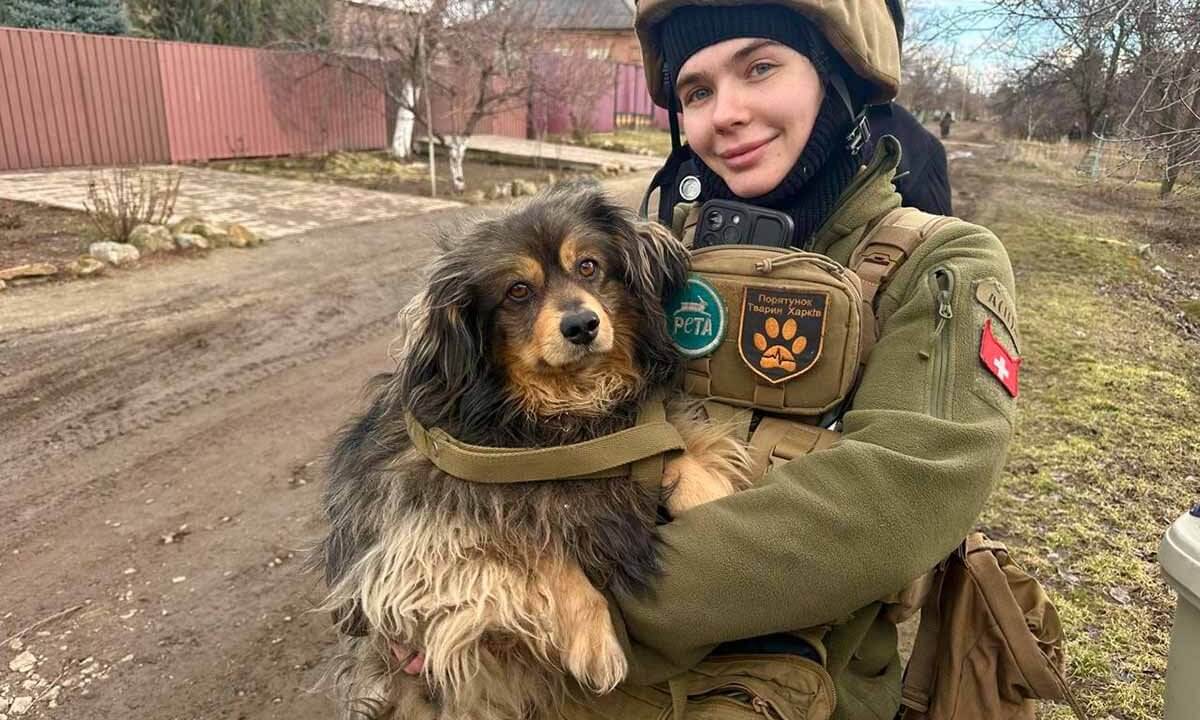Sabrina hält einen geretteten Hund in den Armen und schaut freudenstrahlend in die Kamera.