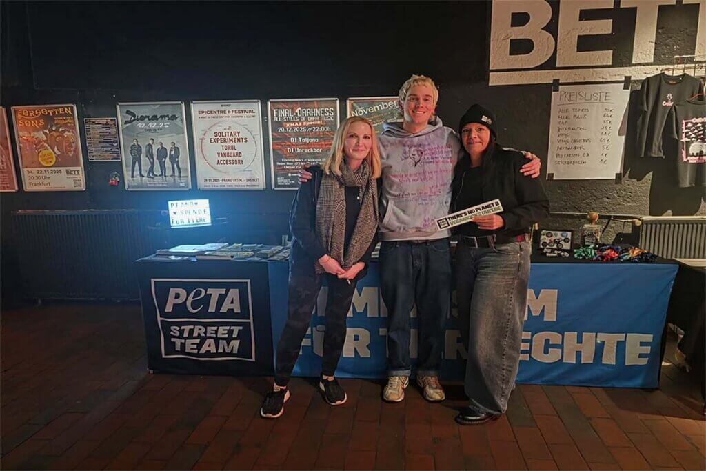 Zwei Peta-Aktivistinnen zusammen mit dem Rapper Conny vor ihrem Stand.