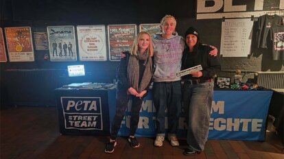 Zwei Peta-Aktivistinnen zusammen mit dem Rapper Conny vor ihrem Stand.