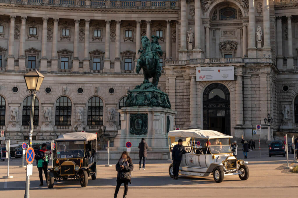 Platz vor Wiener Nationalbibliothek und Papyrusmuseum mit Fahrzeugen für tierfreundliche historische Standrundfahrt