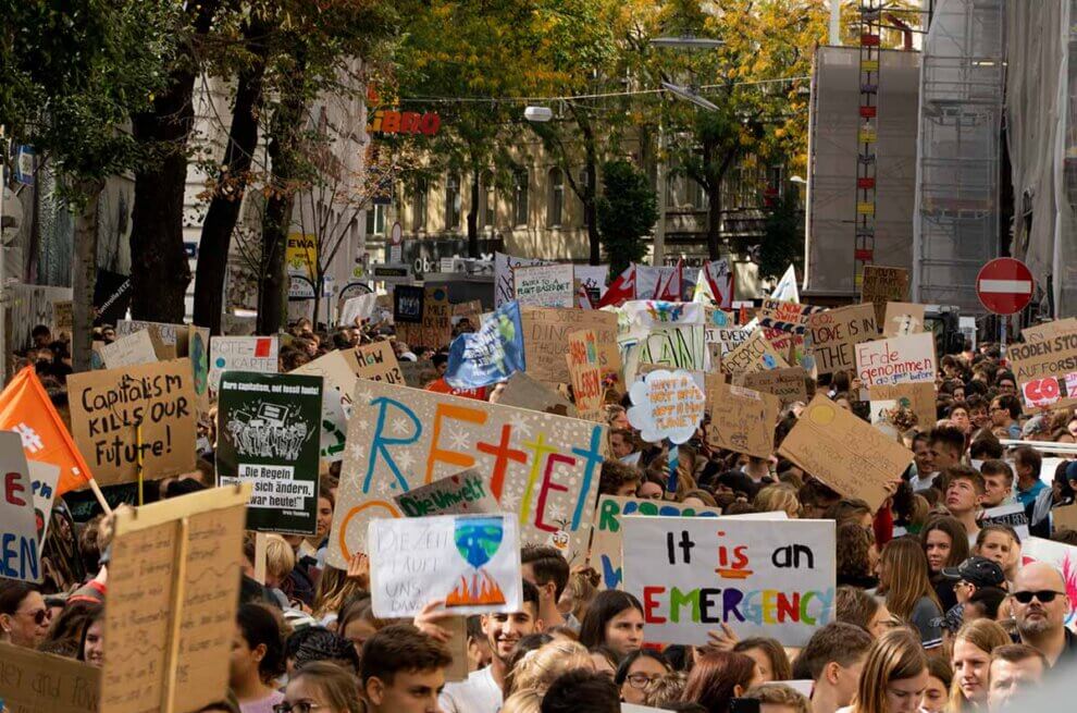 Eine Demonstration mit vielen Menschen und laufen einer Allee entlang.
