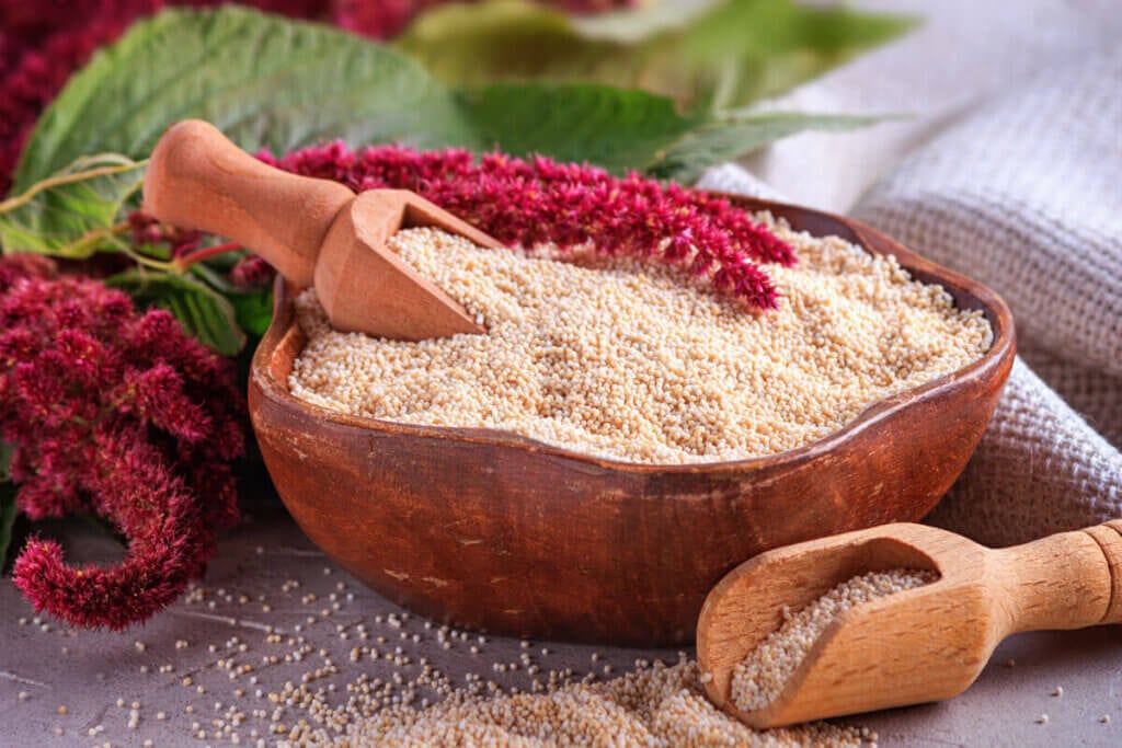 gepuffter Amarant in Holzschüssel mit Amaranthus Pflanze im Hintergrund